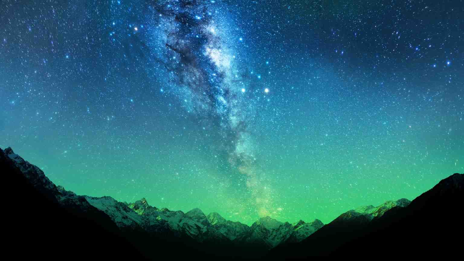 A starry sky above a mountain landscape at night.