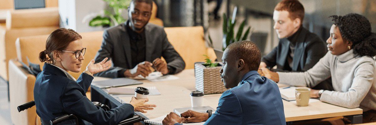 Blog 33 A group of people in business attire sit around a conference table.