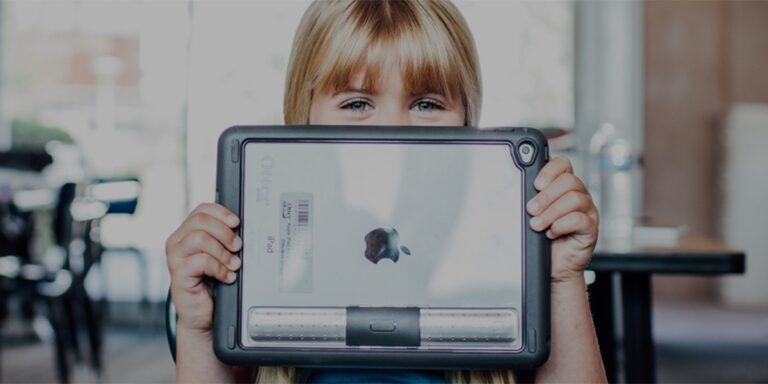 A young child holds a tablet with a protective case of Otter Products