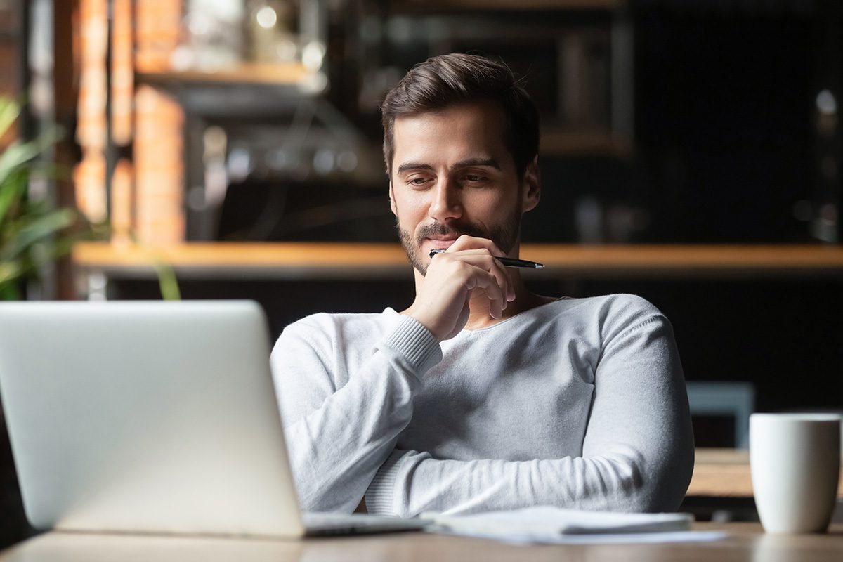 Businessman sitting at desk reading his computer screen.