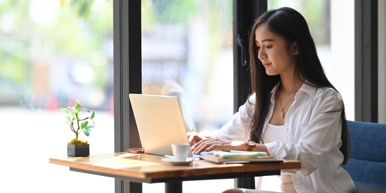 Hire2Retire Phase 5.5: Multi-Domain AD Support, HR File Extract Monitoring, and More 3 A young woman working on a computer at a coffee table.