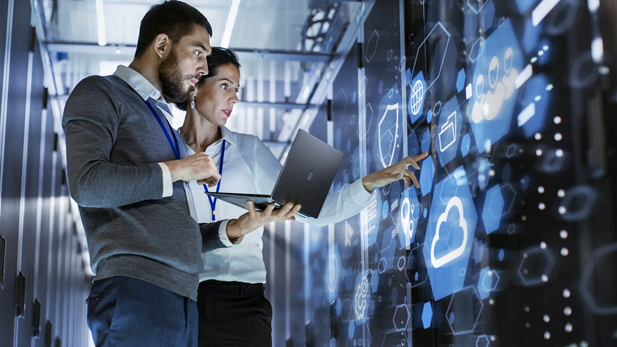 Male IT Specialist Holds Laptop and Discusses Work with Female Server Technician.