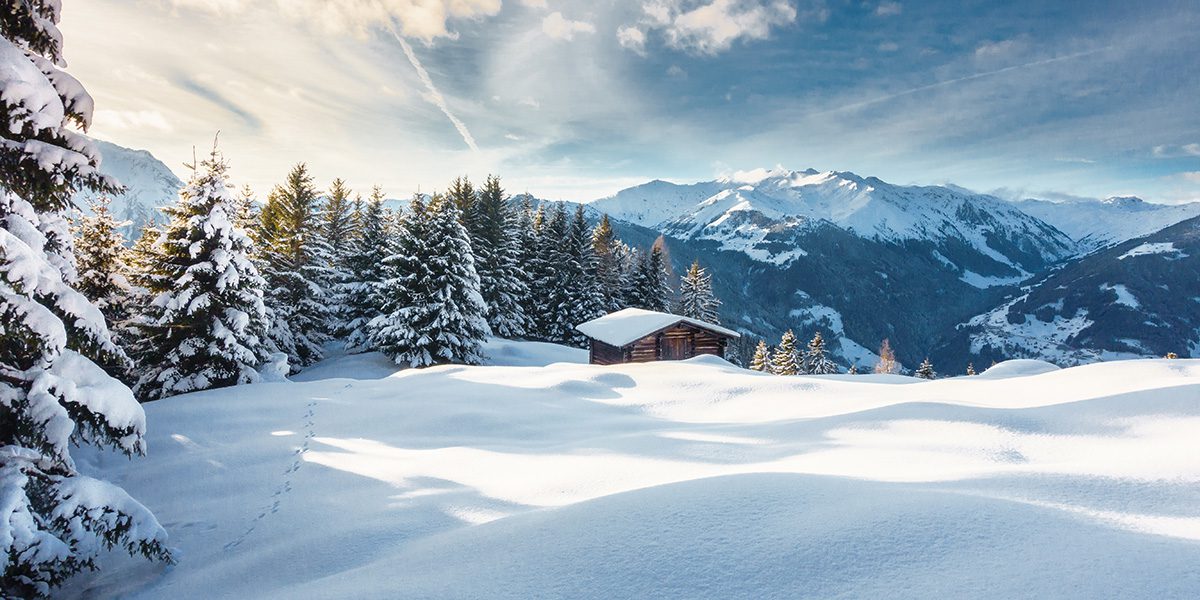 Winter panorama with ski hut in the snow.