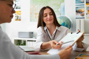 A female looking at a screen while explaining to a middle-aged man.