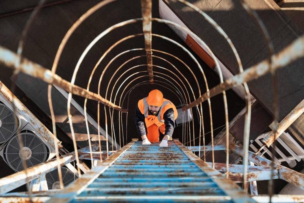 A man with equipment at climbing ladder