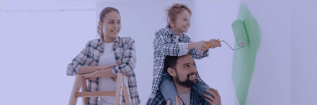 Father and child painting together while mother watches and smiles.