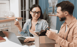 A woman holding a credit card makes an online purchase.