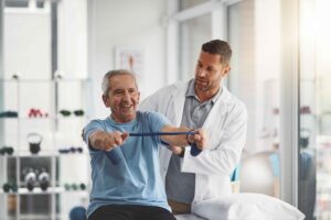 Physiotherapist stretching band and senior patient for consulting medical care