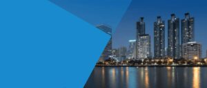 A skyline featuring modern skyscrapers illuminated at dusk.