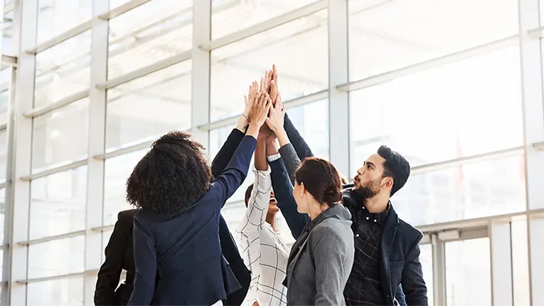 Blog 26 Happy colleagues high-fiving each other, they use Hire2Retire for HR to AD sync up