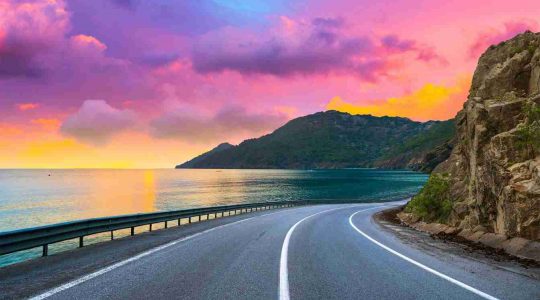 A winding coastal road at dusk.