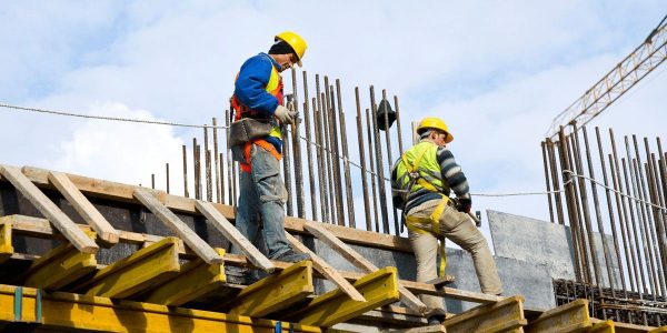 Deux ingénieurs portant des casques de sécurité travaillent sur un projet de construction.