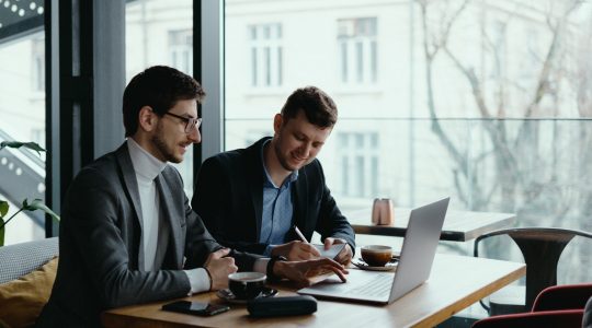 Two young businessman having successful meeting at restaurant discussing Hire2Retire's Ceridian to Okta Directory integration
