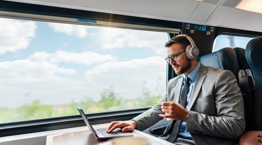 Businessman on a train working on his computer