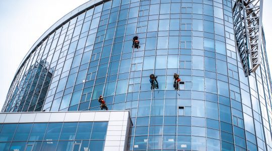 A group of people cleaning windows of a law firm building which used Hire2Retire