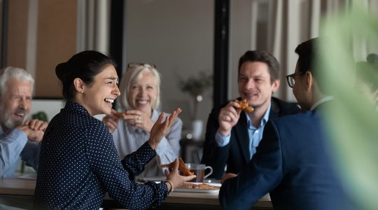 A group of HR employees are smiling and talking while eating lunch. Thanks to UKG Pro to Okta integration, they don’t need to worry about manual, high-volume tasks anymore.