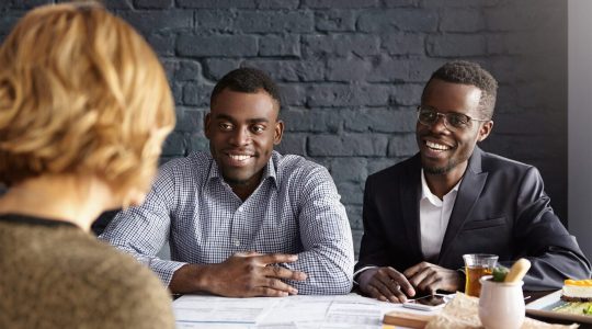 Two African American men in business attire interview a woman. Their organization's onboarding is smooth and easy thanks to Hire2Retire's Workday integration.